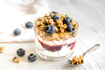 Morning granola with yogurt and berries on white kitchen background