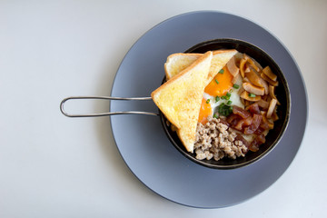 American breakfast contain egg, minced pork, sausage, toast on pan background