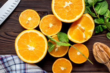 orange juice with mint squeezing on wooden kitchen background top view