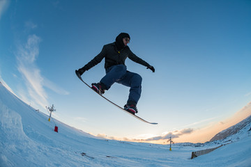 Snowboarder jumping against blue sky