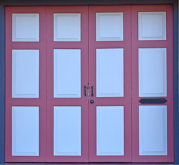 Vintage pink on wooden door panel with old handle