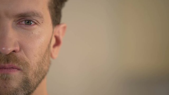 Half face of aggressive man looking with hatred into camera, domestic tyrant