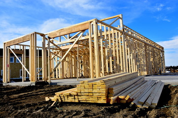 Two story wood frame residential building under construction with material in foreground.