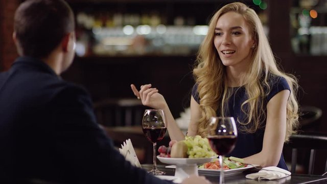 man and woman celebrating a date with red wine