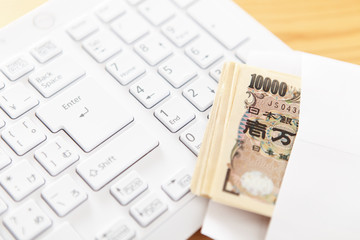 Fototapeta premium キーボードと封筒に入ったお金