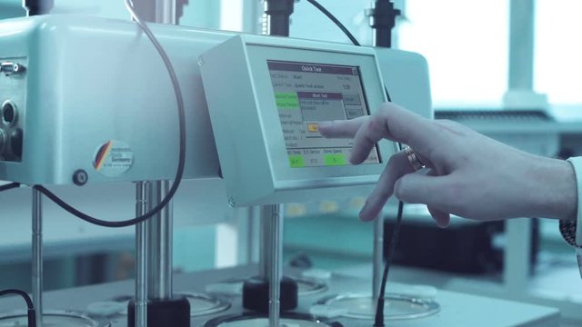 Hand of person putting the settings to the pills solubility tester.