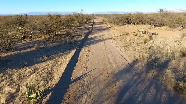 Aerial POV - flying down a desert dirt road at high speed
