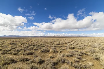  Wide open empty desert landscape in Nevada during winter with blue skies and clouds.  Mountains in the distance. © neillockhart