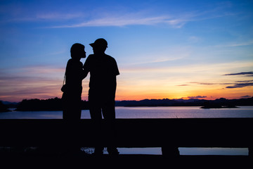 Silhouette of lovely couple on lake