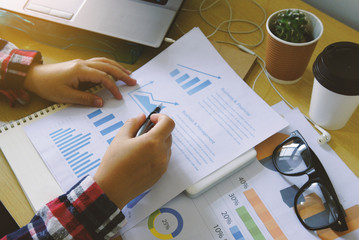 Businesswoman analysis financial paperwork and reports graph
