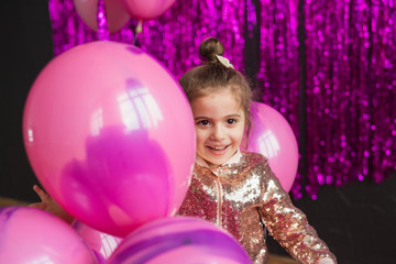 Fototapeta na wymiar Portrait of little girl with pink balloons