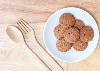 cookie in dish and spoon fork on a wooden background