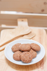 cookie in dish and spoon fork on a wooden background