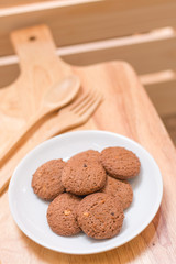 cookie in dish and spoon fork on a wooden background