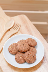 cookie in dish and spoon fork on a wooden background