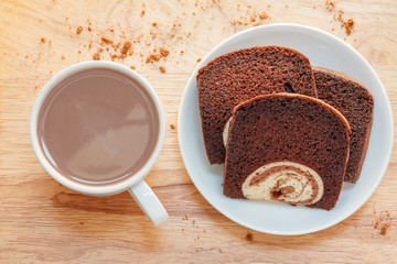 cake in dish and coffee on a wooden background
