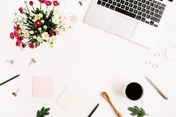 Top view home office table desk frame. Workspace with laptop, wildflowers bouquet, coffee cup, feminine accessories and office stuff. Flat lay.