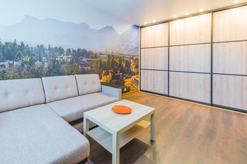 The interior of the living room in orange tones with a coffee table and sofa
