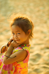 Defocused and blurred image Child kid posing and fun on the beach with golden light at sunset summer