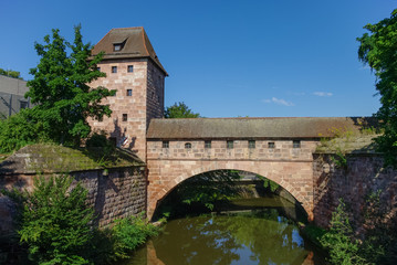 Fototapeta na wymiar Old city walls with an arch reflected in the Pegnitz river, near Steubenbrucke bridge, historic centre, Nuremberg, Bavaria, Germany
