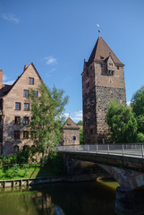 Fototapeta na wymiar Old Tower Schuldturm and Heubrucke bridge across Pegnitz river in Nuremberg old town, Bavaria. Germany