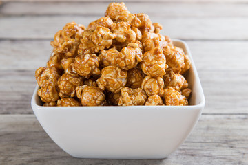 Caramel popcorn on wooden background