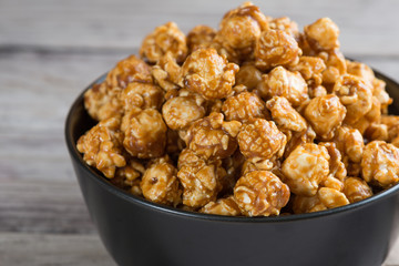Caramel popcorn on wooden background