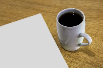 taza de cafe con hoja en blanco 