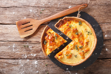 Sliced Savory pie with pumpkin, cheese, chicken and herbs closeup on the table. horizontal top view