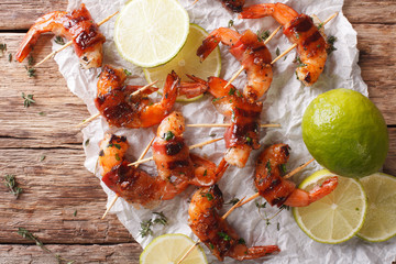 Fried shrimp with bacon, spices and lime close up. horizontal top view