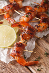 Fried shrimp with bacon, spices and lime close up. vertical