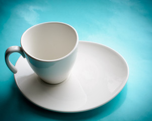 White Cup and saucer on a blue background