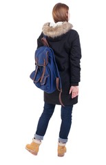 Back view woman in winter jacket  with a backpack looking up