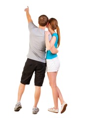 Back view of young couple pointing at wall