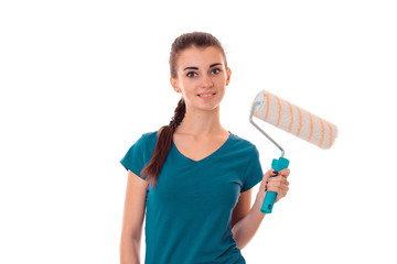 a young girl stands smiling and holding a roller for painting isolated on white background