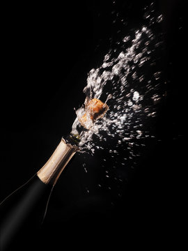 Champagne bottle and spray on black backgroun