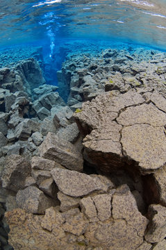 Underwater landscape showing the tectonic boundary between the Eurasian and the North American plates, with a diver in the distance, Silfra, Thingvellir lake, Thingvellir National Park, Iceland, May 2009