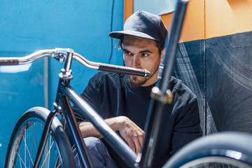 Man in cap looking at bike