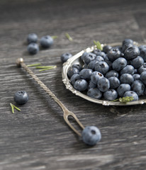 Blueberry in a plate on a wooden background