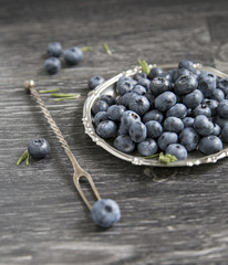 Blueberry in a plate on a wooden background