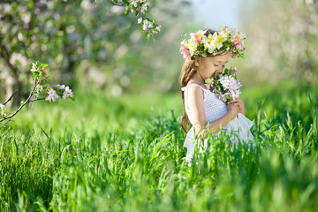 Little girl in garden with flowers 