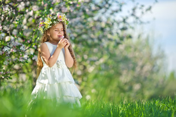 Little girl in garden with flowers 