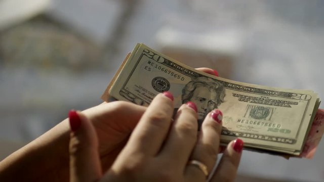 Girl holds banknotes in 20, looks at them, stroking, recount. 4k., 3840x2160