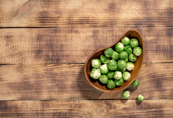 Brussels sprouts in a wooden bowl on wooden table
