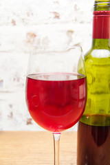 Bottle of red wine with glass ready to pour