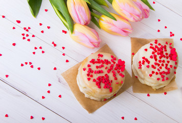 Honey Cake, Sprinkled Red Hearts, with a Bouquet of Tulips on a White Background.