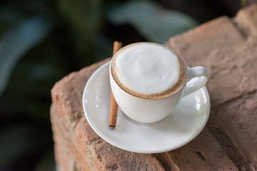 Cup of tasty cappuccino on red brick