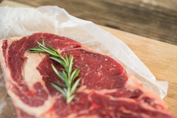 Sirloin chop and rosemary herb on wooden tray