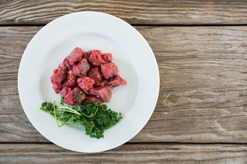 Diced beef and corainder leaves in white plate