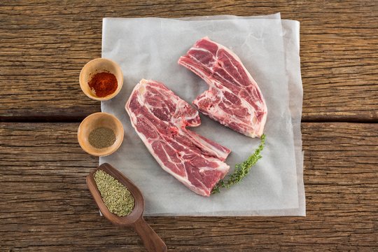 Sirloin steak and ingredients against wooden background